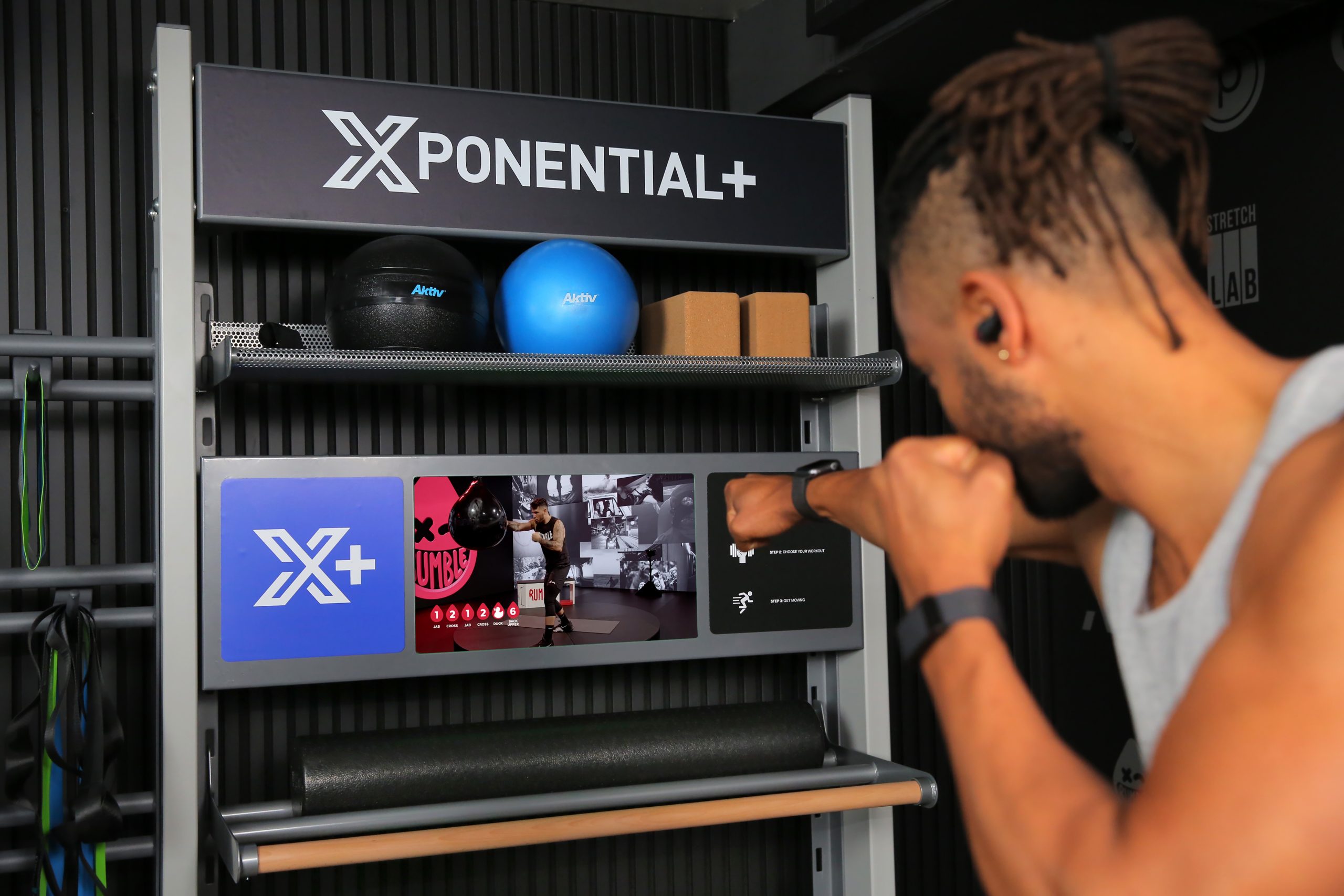 A black man loading an on-demand boxing workout on the Xponential+ virtual fitness machine